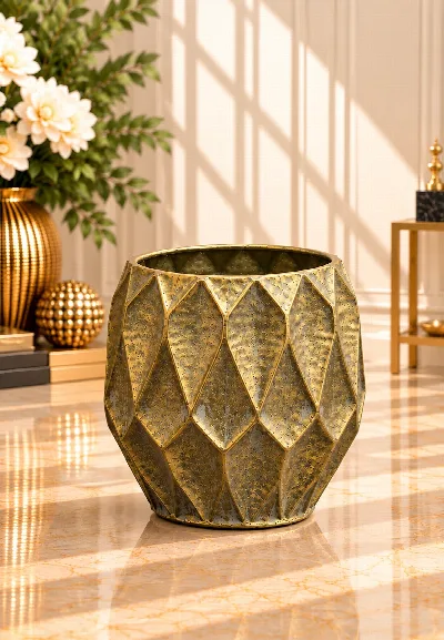 Antik görünümlü altın rengi metal saksı, geometrik elmas desenli yüzeyi ve yuvarlak formuyla